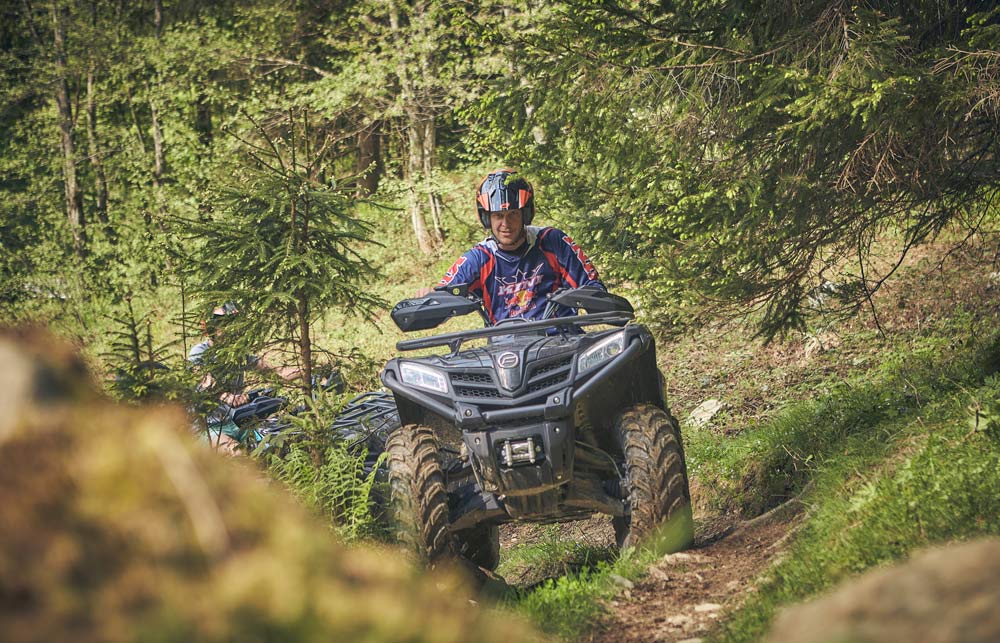 Ein Mann fährt mit einem Quad durch den Wald